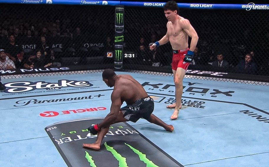 Joaquin Buckley falls to the canvas as Mike Malott stands over him, one second after the knockout blow.